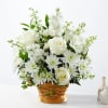 White roses and daisies arranged in a woven basket