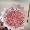 Bouquet of pink roses with white baby's breath in pink wrapping