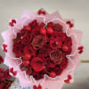 Bouquet of red roses with pink wrapping and red ribbon bows