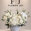 White rose arrangement in a gray vase with eucalyptus accents