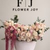 Large blush and cream rose arrangement in a pale vase