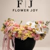 Pink and yellow floral arrangement in a black vase with white orchids