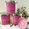 Three labeled candles with a pink dish and decorative berries