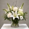 White roses and lilies arranged in a clear glass vase