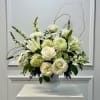White floral arrangement in a white pedestal vase