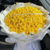 Large bouquet of yellow roses wrapped in white paper