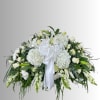 White floral spray with lilies, roses, and hydrangeas tied with a white ribbon