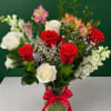 Bouquet of red and white roses with pink alstroemeria in a glass vase