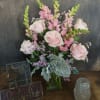 Pink roses and snapdragons arranged in a glass vase