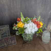 A bright cluster of white hydrangeas paired with sunny yellow roses and