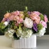 Pink and peach roses with white hydrangeas in a ribbed white vase