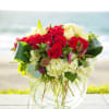 Red and white rose bouquet in a clear glass vase