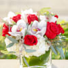 Red roses and white orchids arranged in a clear glass vase
