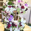 Large floral arrangement shaped like the number 5 with pink, white, and purple blooms