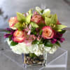 Bouquet of pink roses, orchids, and white hydrangeas in a glass vase