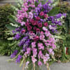 Large standing floral spray with pink and purple roses and blossoms