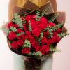 Bouquet of red roses with eucalyptus in dark wrapping