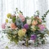 Mixed pastel flower arrangement in a low pedestal vase