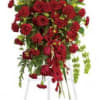Tall standing spray of red roses and carnations on a white easel