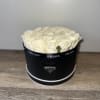 Cream roses arranged in a black round box with Prada branding