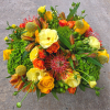 Bright bouquet of yellow, orange, and red flowers with green accents