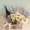 Gift box with flowers, wine, and chocolate bar tied with a white ribbon