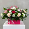 A chic floral arrangement featuring a mix of roses and seasonal flowers