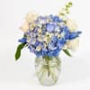 Blue and white hydrangea bouquet in a clear glass vase
