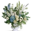 White and blue floral arrangement in a white pedestal vase