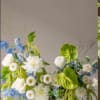 Wedding floral arrangement with white and blue flowers in a low bowl
