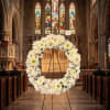 White floral wreath on a stand inside a church