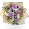 Bouquet of lavender and white flowers wrapped in tan paper