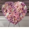 Heart-shaped pink and lavender floral arrangement on an easel