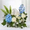 Blue and white floral sympathy arrangement with a memorial stone