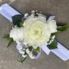 A small arrangement of beautiful flowers and greens secured to a snap