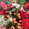 Bouquet of red and pink flowers with white daisies and eucalyptus