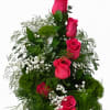 Tall arrangement of hot pink roses with white baby's breath in a black vase
