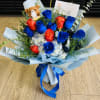 Bouquet of blue and red roses with a small teddy bear and ribbon wrap