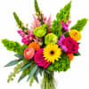 Bright mixed bouquet in a clear glass vase with roses, gerbera daisies, and green blooms