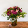 Purple and pink bouquet in a glass vase with eucalyptus