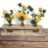 A rustic driftwood vase is the perfect vessel to hold these wildflowers.