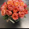 Bouquet of peach and pink roses in a dark vase