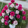 Pink and pale roses arranged in a white vase outdoors