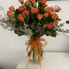 Orange roses in a glass vase with an orange ribbon