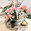 Pink rose bouquet with baby's breath, ribbon, and chocolates on a floral tray