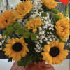 Bouquet of sunflowers, green button mums, and baby's breath in a glass vase
