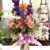 Mixed bouquet in a glass vase with a pink ribbon