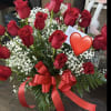 Red roses with baby's breath in a glass vase and red ribbon