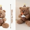 Plush teddy bear holding a cupcake and wearing a birthday hat