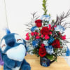 Bouquet of red roses and blue carnations in a Stitch mug beside a plush Stitch toy